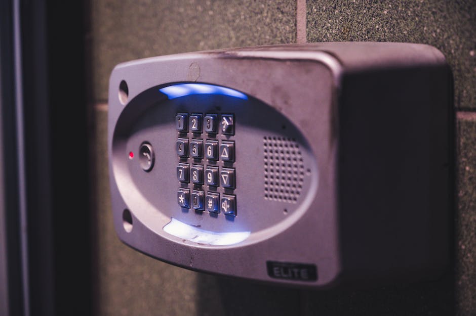 Digicode d'immeuble fixé sur un mur en pierre, clavier rétroéclairé