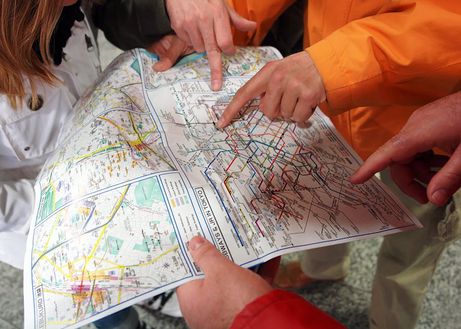 Plusieurs personnes pointent ensemble vers une carte de transports, illustrant l'orientation des voyageurs étrangers
