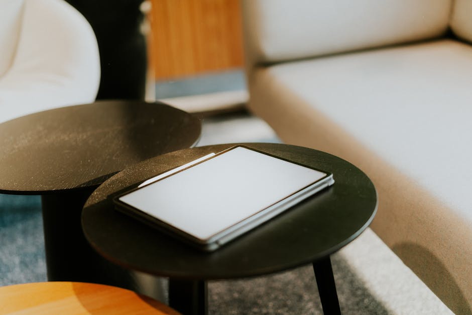 Tablette posée sur une table basse dans un salon contemporain, prête à présenter un livret d'accueil numérique